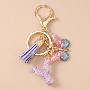 Dettaglio del portachiavi con lettera Y glitterata con nappa viola e ciondolo a farfalla