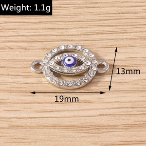 Macro detail of evil eye jewelry charm with rhinestones and blue enamel inlay