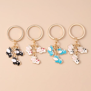 Cartoon cow keychains with cute enamel patterns and golden metal rings in four colors
