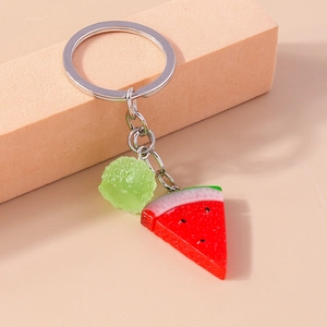 Détail d'un pendentif pastèque en résine avec une boule de bonbon givrée sur un porte-clés
