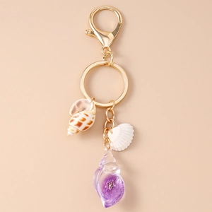 Detailed close-up of summer ocean themed shell keychain with golden metal ring