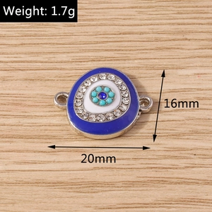 Macro detail of oval evil eye charm with blue enamel and sparkling rhinestones