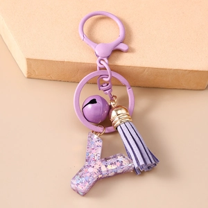 Détail du porte-clés lettre Y violette avec paillettes scintillantes et gland en cuir