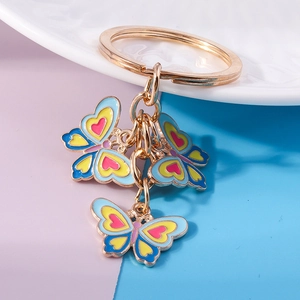 Dettaglio di portachiavi a farfalla colorati in blu, giallo e rosa con anello dorato
