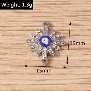 Macro view of sun-shaped evil eye jewelry charm with blue resin and clear rhinestones
