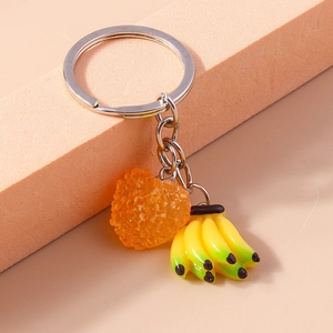 Gros plan détaillé d'un porte-clés argenté avec des bananes et un pendentif coeur orange