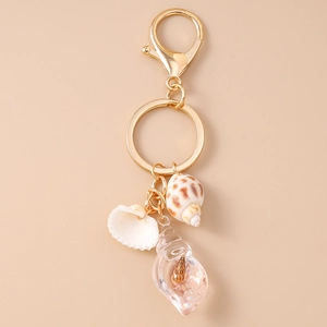 Detailed view of beach shell keychain with conch and resin charms on gold ring