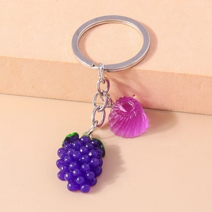 Détail d'un porte-clés raisin créatif avec fruit en résine violette et disque en spirale