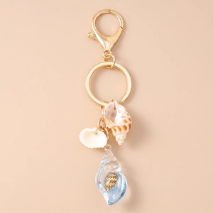 Detail of nautical keychain featuring shells and resin shell pendant on a golden ring