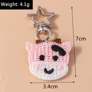 Détail du porte-clés vache rose tricoté avec fermoir étoile argenté et dimensions