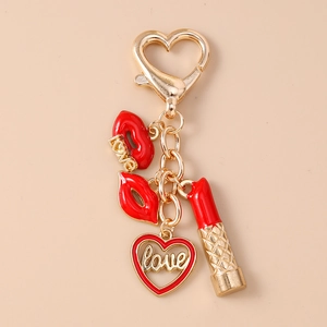 Λεπτομέρεια χρυσού μπρελόκ με κόκκινα χείλη και καρδιά με τη λέξη αγάπη