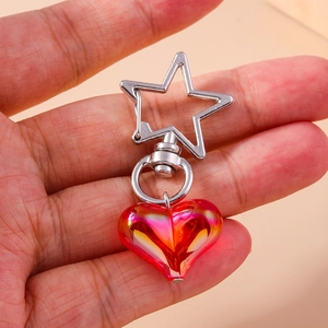 Detail of red-pink gradient translucent heart pendant with silver star-shaped clasp
