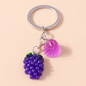 Gros plan d'un porte-clés de grappe de raisin violette avec feuilles et anneau argent