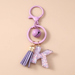 Détail du porte-clés violet avec cloche pompon et lettre K en résine avec paillettes
