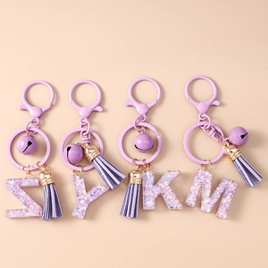 Porte-clés initiales en résine violette avec paillettes, pompon et cloche pour sacs