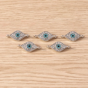 Macro detail of evil eye jewelry connectors with sparkling rhinestones for DIY crafts