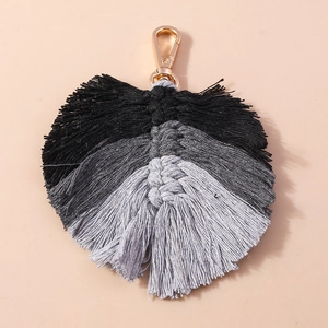 Detailed close-up of handmade woven leaf tassel keychain with grey gradient cotton cord