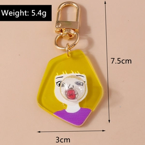 Detailed macro view of creative acrylic keychain with cartoon girl and golden metal clasp