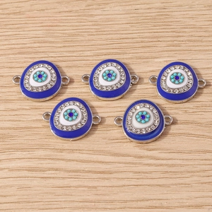 Detail of silver evil eye charms with blue gemstones and rhinestones for DIY jewelry