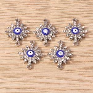 Detail of silver evil eye flower connectors with rhinestones and blue enamel for DIY jewelry