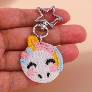 Detail of a handmade unicorn embroidery keychain with a star-shaped silver metal clasp