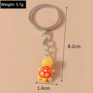 Detail view of yellow turtle keychain with red shell pattern and measurement markings