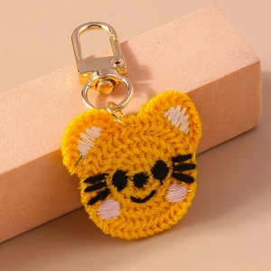 Détail d'un porte-clés tigre tricoté main avec fermoir mousqueton doré brillant
