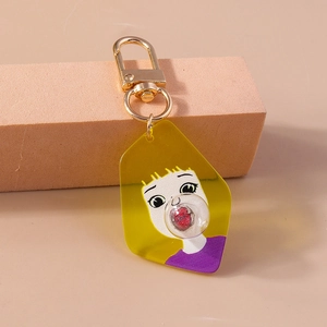 Detail of cartoon girl acrylic keychain featuring a 3D red glitter bubble and gold clasp