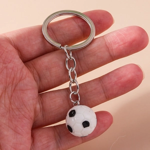 Portachiavi da calcio classico bianco e nero con anello in metallo lucido in mano