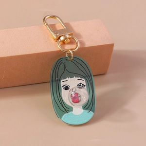 Detail of creative acrylic keychain featuring a girl blowing bubbles with gold D-ring