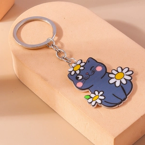 Gros plan du porte-clés chat bleu de dessin animé avec marguerites blanches