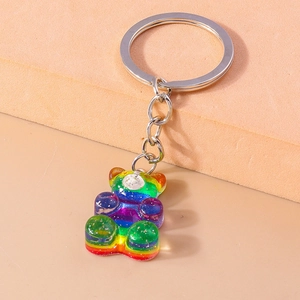 Détail d'un porte-clés ours en résine arc-en-ciel avec paillettes dorées et anneau métal