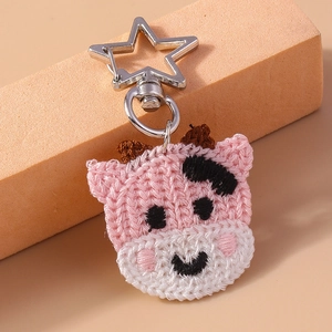 Détail d'un porte-clés vache crocheté à la main avec fermoir en métal en forme d'étoile
