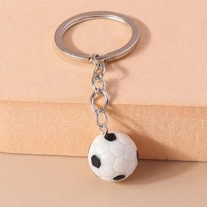 Dettaglio di un portachiavi da calcio bianco e nero con anello e catena in metallo argentato