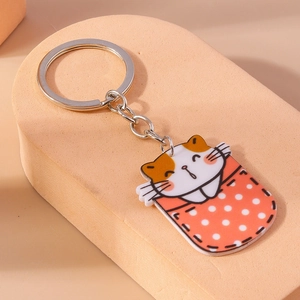 Gros plan d'un porte-clés chat en acrylique dans une poche rouge sur socle rose