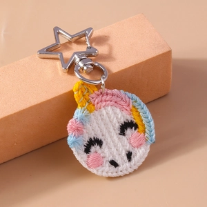 Detail of handmade embroidered unicorn keychain with silver star-shaped metal clasp