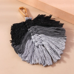 Macro detail of handmade knit leaf keychain with black and grey gradient tassel
