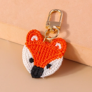 Detailed view of hand-knitted orange fox keychain with high-quality golden lobster clasp