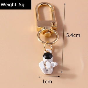Close-up of a white astronaut keychain with size 5.4cm and weight 5g on pink background