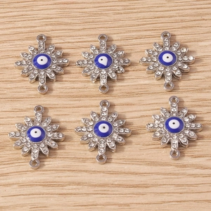 Detailed view of silver evil eye sunburst charms with crystal rhinestones for DIY jewelry