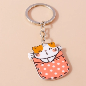Détail du porte-clés chat mignon en acrylique avec un motif de poche rouge à pois blancs
