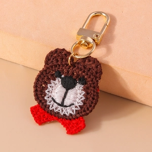 Handmade brown crochet bear keychain with red bow and secure gold metal lobster clasp