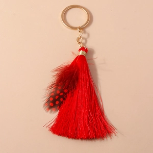 Detailed view of bohemian red feather keychain with elegant silk tassels and gold metal ring
