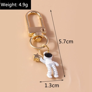 Astronaut keychain with star detail and dimensions showing weight 4.9g and height 5.7cm