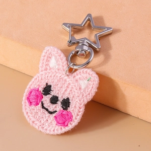Gros plan d'un porte-clés lapin rose au crochet avec crochet en métal argenté en forme d'étoile