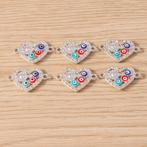 Macro view of heart-shaped evil eye charms with rhinestones for DIY jewelry making