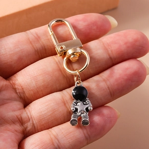 Astronaut keychain pendant featuring a vintage silver metal spacer and golden ring