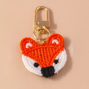 Detailed view of handmade crochet fox keychain with orange weave and golden clasp