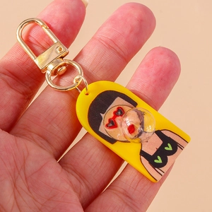 Close-up of yellow acrylic keychain with cartoon character and gold lobster clasp