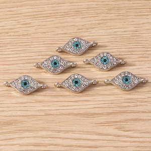 Close-up of silver evil eye connectors with blue and white rhinestones for DIY jewelry